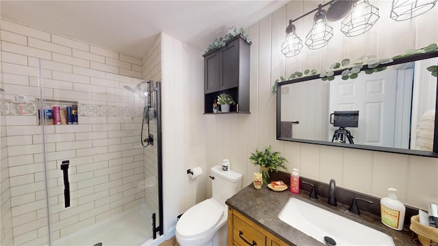 full bathroom with toilet, a stall shower, and vanity