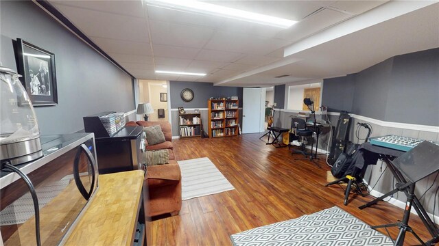 living room featuring a drop ceiling and wood finished floors
