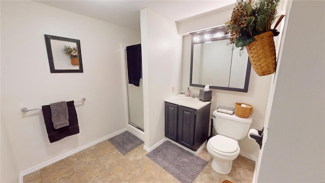 full bathroom featuring a shower stall, vanity, baseboards, and toilet