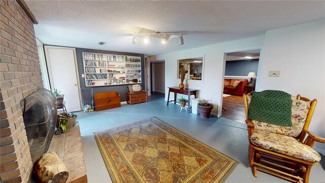living room featuring a textured ceiling and a fireplace