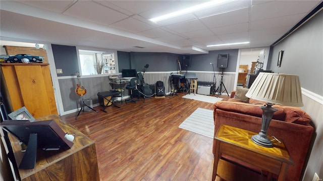 living area featuring a paneled ceiling and wood finished floors