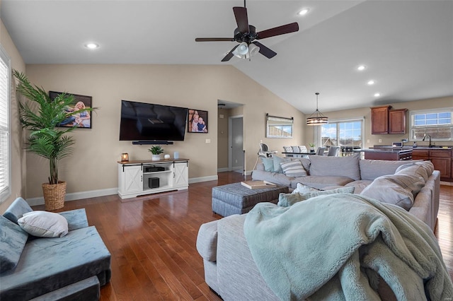 living area featuring dark wood-style flooring, ceiling fan, vaulted ceiling, and baseboards