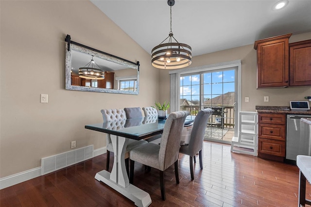 dining area featuring a chandelier, wood-type flooring, vaulted ceiling, and visible vents