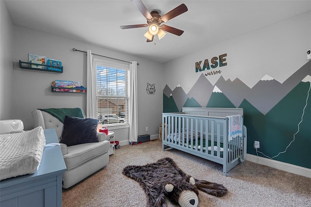 bedroom with carpet floors, baseboards, and a crib