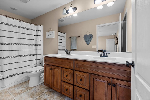 bathroom with toilet, double vanity, a sink, and visible vents