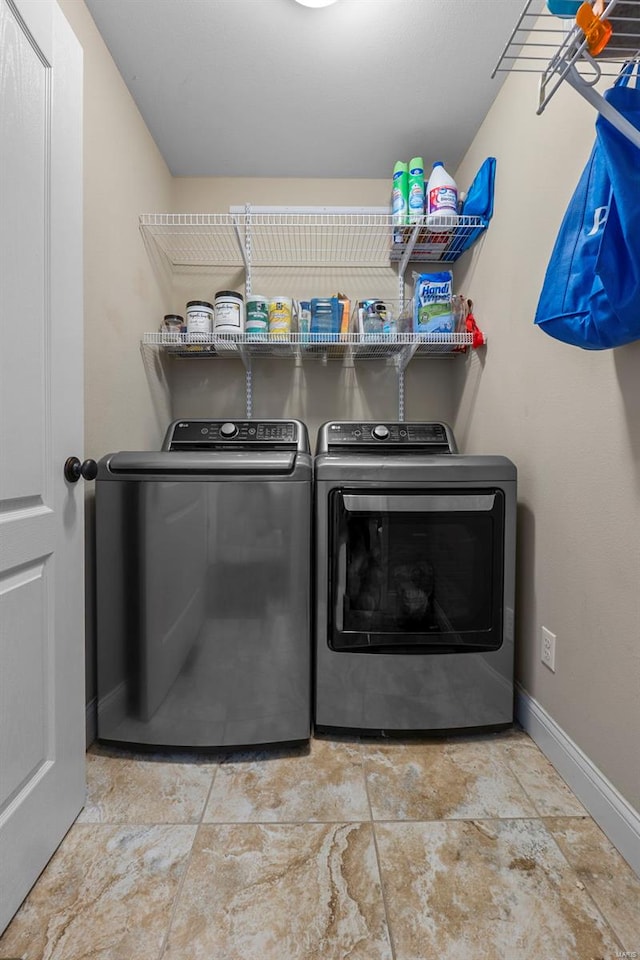 laundry area featuring washing machine and clothes dryer, laundry area, and baseboards