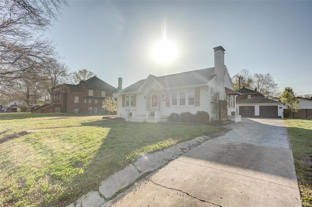 view of front of home with a front lawn, a chimney, and an outbuilding