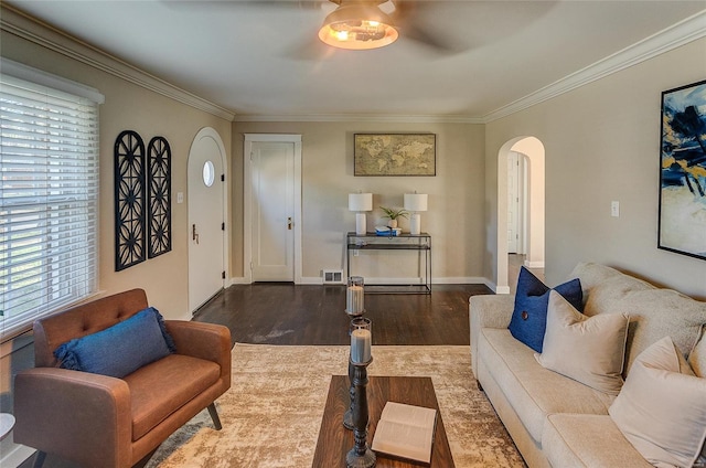living area with crown molding, visible vents, ceiling fan, arched walkways, and wood finished floors