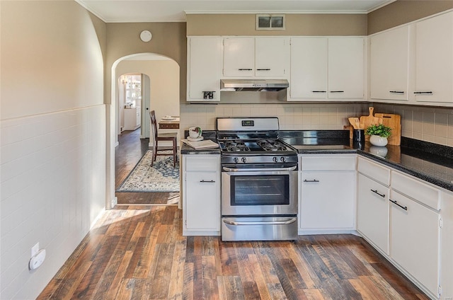 kitchen featuring white cabinetry, under cabinet range hood, visible vents, arched walkways, and stainless steel gas stove