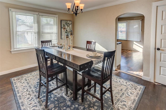 dining space with crown molding, arched walkways, wood finished floors, baseboards, and a notable chandelier