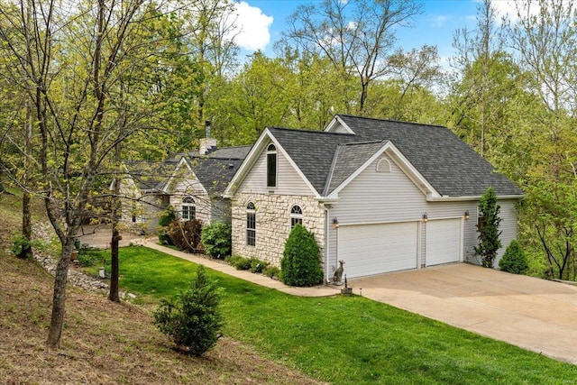 view of front of house featuring concrete driveway, stone siding, a shingled roof, a front yard, and a garage