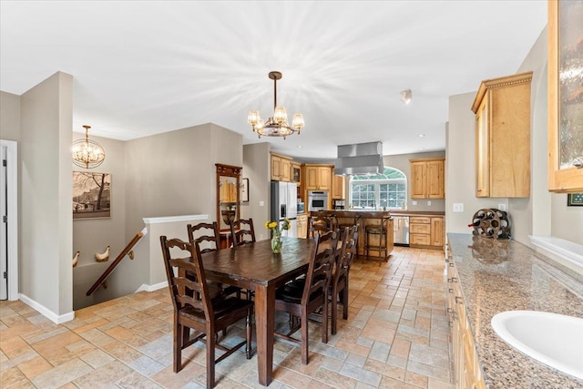 dining room featuring stone tile floors, baseboards, a notable chandelier, and recessed lighting
