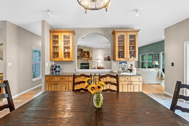 dining space featuring recessed lighting, arched walkways, baseboards, and a fireplace