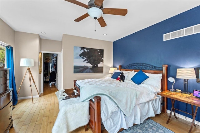bedroom featuring baseboards, visible vents, hardwood / wood-style flooring, and a ceiling fan
