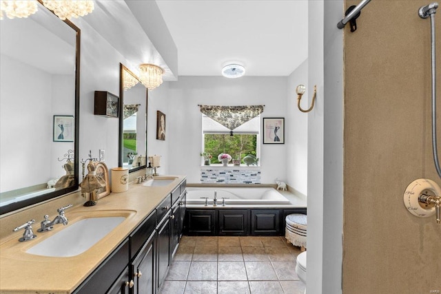 bathroom featuring toilet, a garden tub, double vanity, and a sink