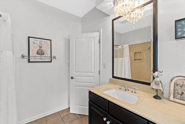 bathroom with an inviting chandelier, vanity, tile patterned floors, and baseboards