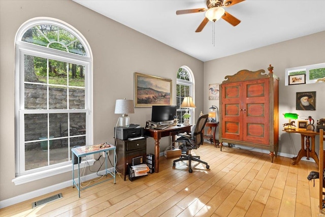 office area with visible vents, ceiling fan, a wealth of natural light, and hardwood / wood-style floors