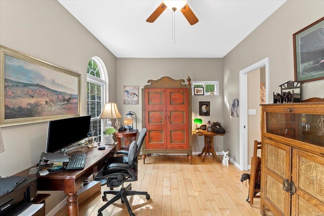 office area with light wood finished floors, a ceiling fan, and baseboards