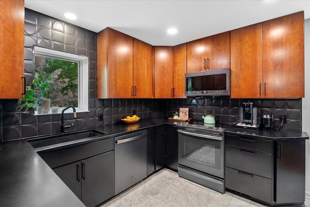kitchen with brown cabinets, dark countertops, a sink, stainless steel appliances, and tasteful backsplash