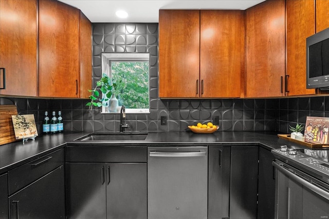 kitchen featuring electric range, dark countertops, a sink, backsplash, and stainless steel dishwasher