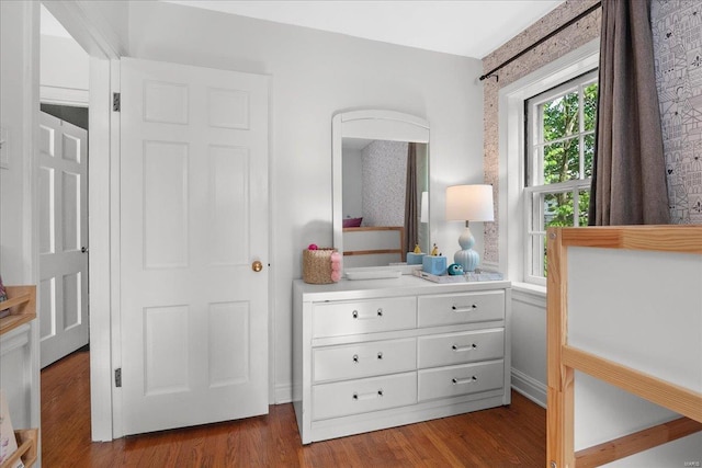 bedroom with baseboards and wood finished floors