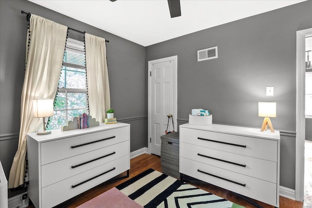 bedroom featuring visible vents, dark wood finished floors, ceiling fan, and baseboards