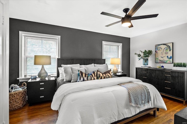 bedroom with a ceiling fan, multiple windows, and wood finished floors