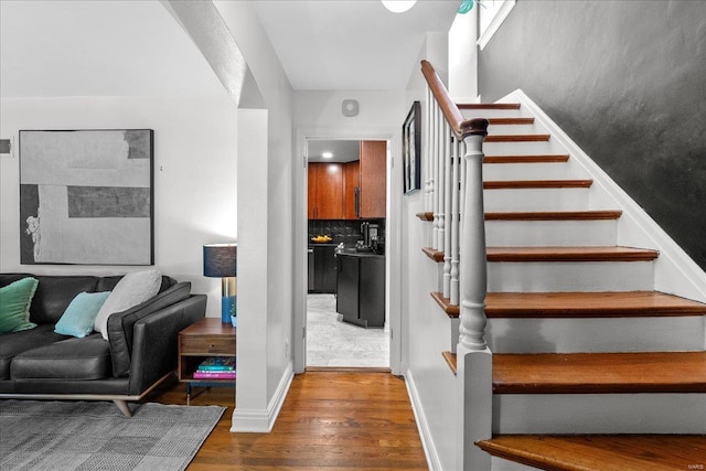 staircase with baseboards and wood finished floors