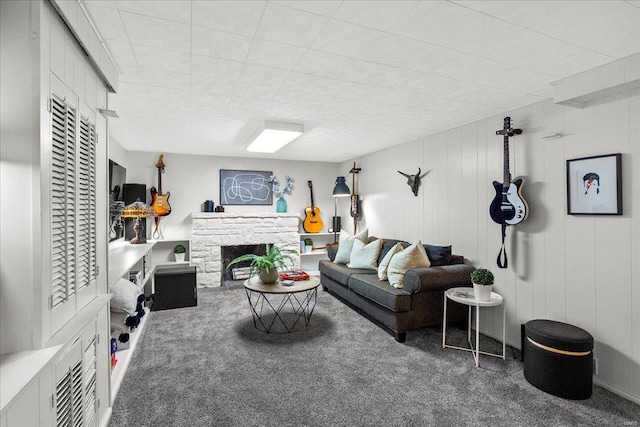 living area featuring carpet flooring and a stone fireplace
