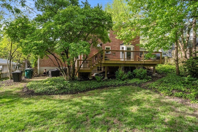 rear view of property with fence, a yard, a deck, and brick siding