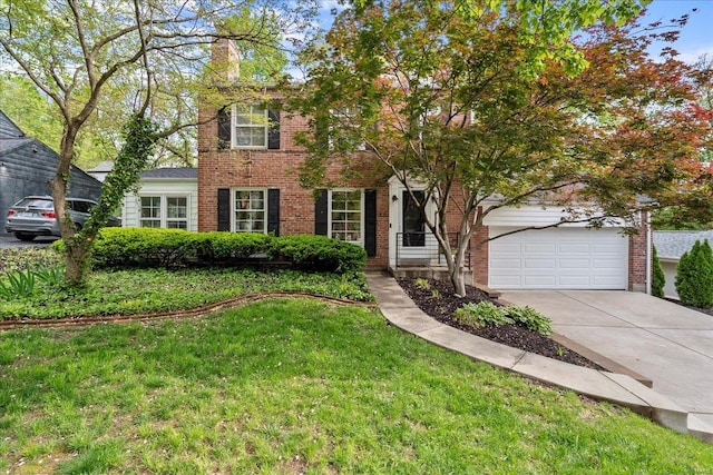 view of front of property with driveway, a chimney, a front yard, brick siding, and an attached garage