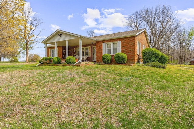 single story home with a porch, brick siding, and a front lawn