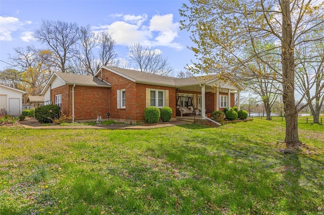 single story home with a front yard, brick siding, and covered porch