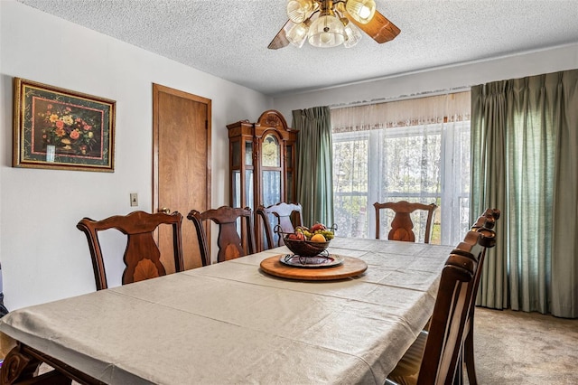 carpeted dining area with a textured ceiling and a ceiling fan