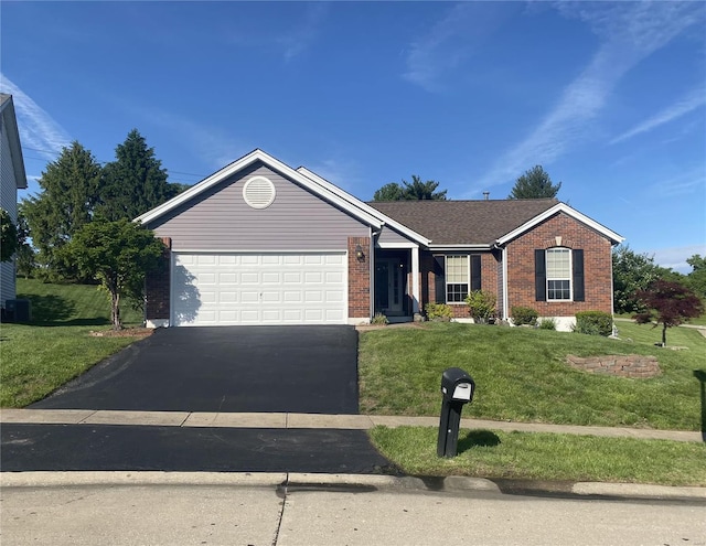 single story home featuring an attached garage, driveway, a front lawn, and brick siding