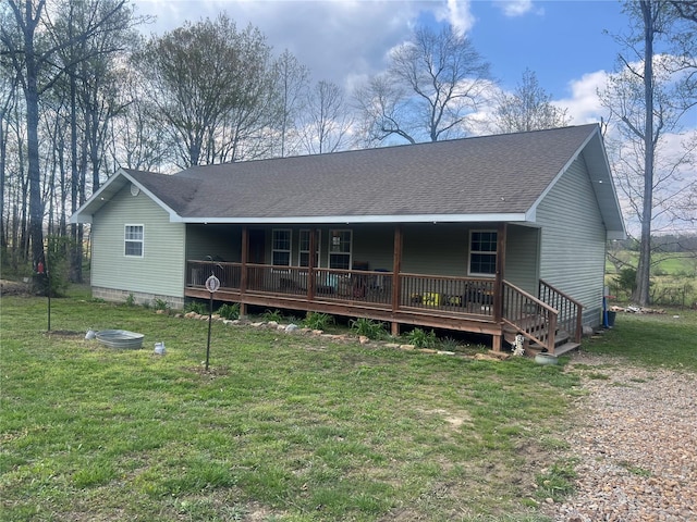 back of property featuring roof with shingles and a lawn