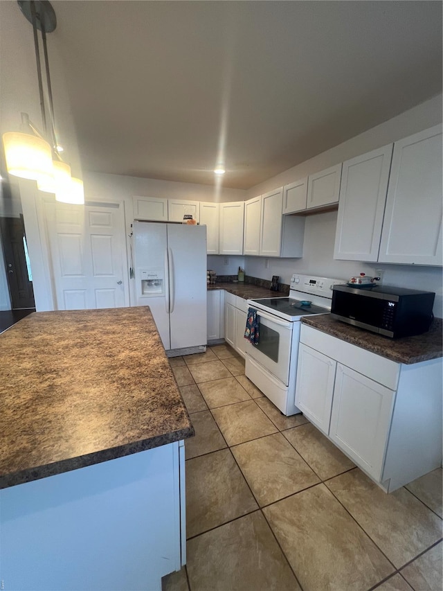 kitchen featuring light tile patterned floors, dark countertops, white appliances, and white cabinets