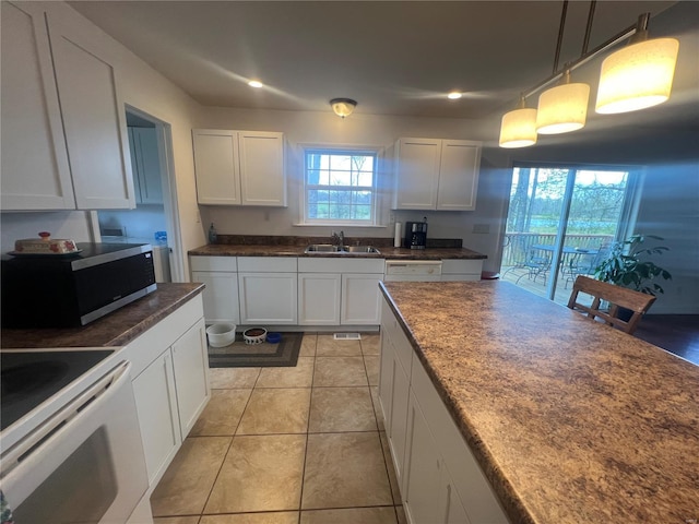 kitchen with white cabinets, white appliances, a sink, and dark countertops