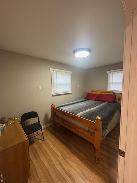 bedroom featuring light wood-style floors and baseboards