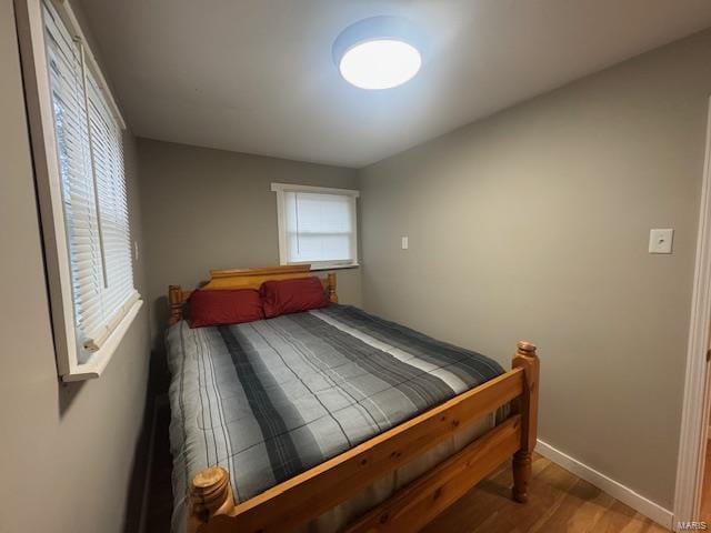 bedroom featuring baseboards and wood finished floors