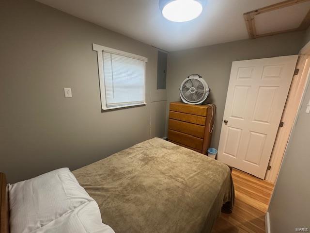 bedroom with attic access and wood finished floors
