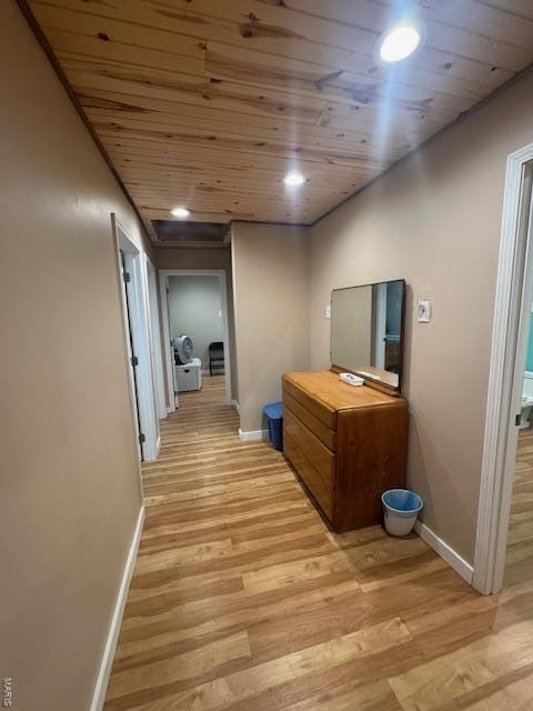 hallway featuring baseboards, light wood finished floors, wooden ceiling, and recessed lighting