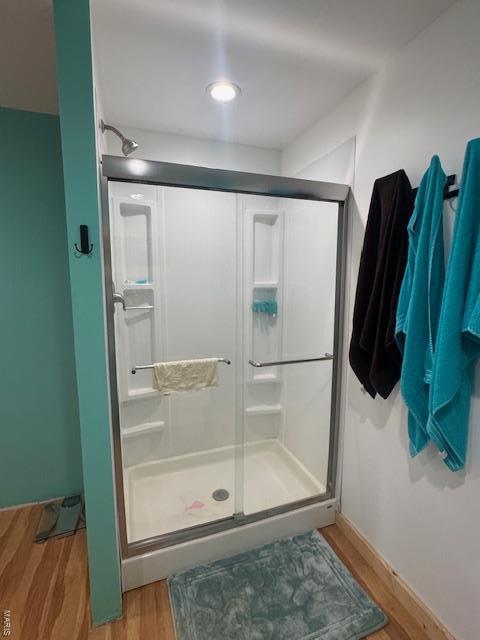 bathroom featuring a stall shower and wood finished floors