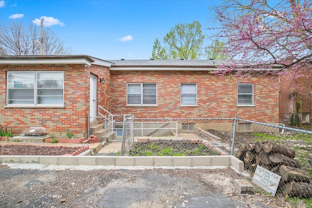 view of front facade featuring brick siding and fence