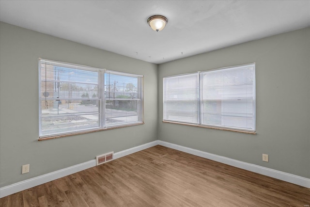 unfurnished room featuring baseboards and wood finished floors