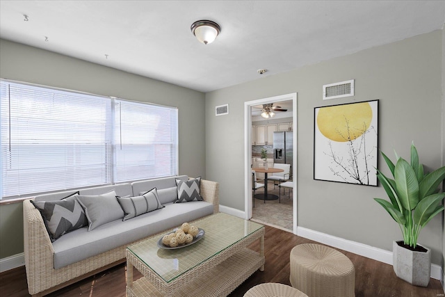 living area with visible vents, baseboards, a ceiling fan, and wood finished floors
