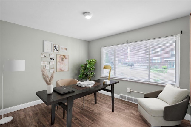 home office featuring visible vents, baseboards, and wood finished floors