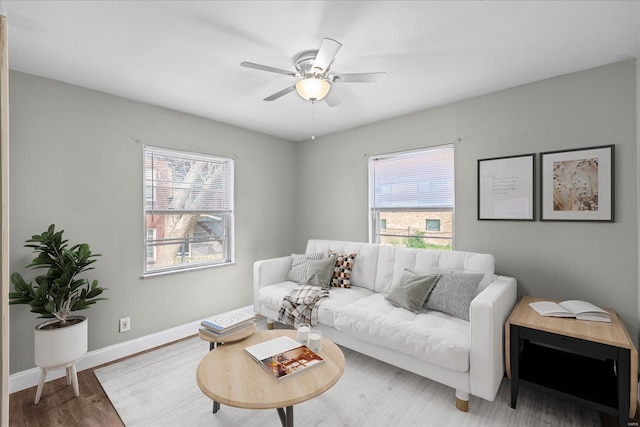 living room with baseboards, a ceiling fan, and wood finished floors