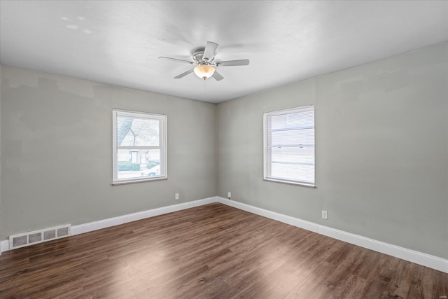 spare room with visible vents, baseboards, a ceiling fan, and wood finished floors