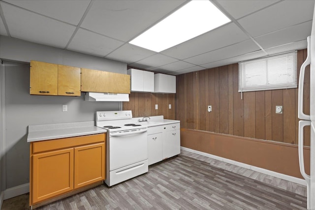 kitchen with a paneled ceiling, light wood-type flooring, white appliances, light countertops, and under cabinet range hood